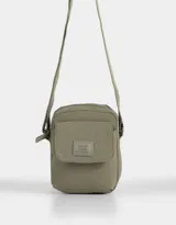 Bandolera verde militar de tela deportiva con bolsillo frontal con solapa, correa regulable, cierre superior y tag frontal con la inscripción "No Bad Vibes Allowed".