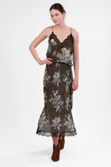 Top verde con estampado de figuras mitológicas en blanco y negro, escote en V con encaje negro y tirantes finos.