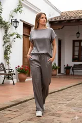 Conjunto de poliéster color gris topo, compuesto por una blusa de mangas cortas y un pantalón de corte recto con cintura elástica.