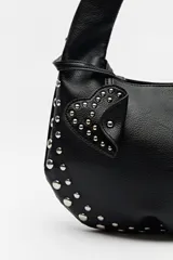 Cartera hobo negra de símil cuero con tachas metálicas plateadas.
