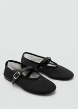 Zapato tipo ballerina de malla negra con puntera redondeada y tira con hebilla sobre el empeine.