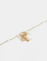 Collar corto dorado con cadena de eslabones y perlas, con ramillete de dijes folk: bota campera, corazón y moneda con perla.