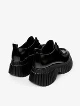 Zapato de piel vacuna color negro con cordones, plantilla reciclada OrthoLite y suela XL EXTRALIGHT de EVA con diseño plisado. Tacón de 6,6 cm y forro interior de piel vacuna.