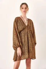 Vestido corto con estampado animal print en tonos marrones y negros, escote en V y mangas largas abullonadas.