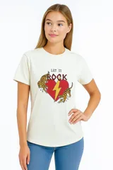 Remera color crudo de corte recto con estampado de un corazón rojo atravesado por un rayo amarillo, con la inscripción "Let it Rock" y dos tigres a los costados.