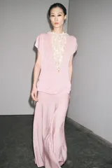 Top de punto color rosa, de cuello redondo y manga corta ancha.