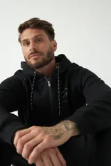 Campera de felpa color bordó con capucha y cordón ajustable, cierre frontal con cremallera, bolsillos laterales y logo estampado en el pecho.