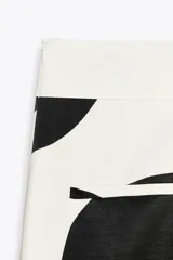 Pantalón de tiro medio confeccionado con hilatura en mezcla de viscosa y lino. Diseño con lunares grandes en blanco y negro. Pierna ancha con detalle de raya planchada. Cierre lateral con cremallera oculta en costura.