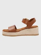 Sandalias negras con plataforma de yute, tira ancha sobre los dedos y tira con hebilla dorada alrededor del tobillo.