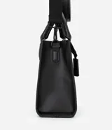 Cartera satchel negra de material sintético con textura diagonal, doble asa de mano y asa larga removible de gross. Incluye porta monedas y cierre por cremallera.