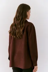 Chaqueta de ante color burdeos, con cierre frontal y múltiples bolsillos.