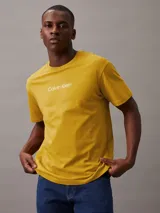 Remera amarilla de algodón con cuello redondo y logo de Calvin Klein estampado en el pecho.