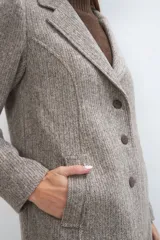 Tapado corto entallado color marrón claro con textura de espiga, cuello solapa y manga larga. Cierre frontal con botones.