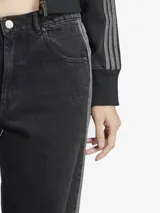 Pantalón de jean Adidas, corte ancho, color negro con las tres tiras blancas a los costados.