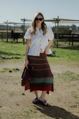 Pollera midi tejida en hilado 100% algodón, color marrón con rayas horizontales en tonos rojo y verde.