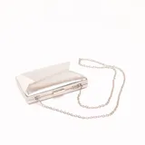 Sobre de fiesta plateado con solapa geométrica y cadena metálica extraíble.