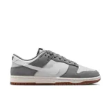 Championes Nike Dunk Bajo Retro SE, color gris y blanco, con detalles en marrón en la suela.
