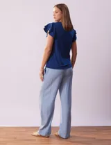 Blusa azul con cuello redondo, escote en V con aplique metálico y mangas cortas con volados en capas.