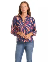 Camisa de gasa estampada con motivos de hojas en tonos azul marino, fucsia y salmón. Presenta cuello con solapa, apertura central con botones y mangas amplias de largo tres cuartos con terminación fruncida.