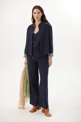 Pantalón de lino azul marino de corte recto con cintura alta y cordón ajustable. Presenta costuras en contraste color blanco.