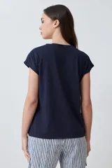 Remera color durazno con escote en V y detalle de vainillas en los laterales. De manga corta y corte recto.