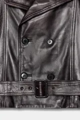 Cazadora biker de cuero color marrón oscuro, con cuello solapa de muescas, doble botonadura cruzada, cinturón ajustable con hebilla y mangas largas con cintas ajustables con hebilla.