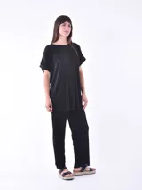 Blusa negra de corte holgado y mangas cortas, con textura plisada.