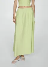 Falda larga color verde lima, de tiro medio y diseño evasé. Confeccionada en mezcla de algodón y lyocell, con cierre de cremallera invisible en la parte posterior.