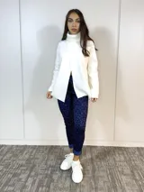 Sweater blanco de cuello alto con abertura frontal.