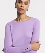 Suéter de punto color verde, con cuello barco, mangas largas y textura acanalada.