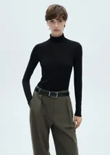 Camiseta negra de cuello alto y manga larga, corte ajustado.