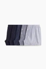 Pack de cinco calzoncillos boxer de algodón con cintura elástica, piernas largas y cierre de botón. Incluye calzoncillos lisos en azul marino, a rayas verticales en azul y blanco, y a cuadros en azul y blanco.