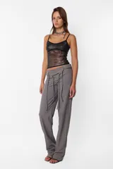 Pantalón de vestir gris, de corte recto y tiro medio. Presenta detalle de falsa cintura con presillas y cinto tira incluido.