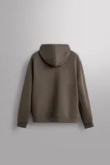 Sudadera con capucha color marrón topo, de corte regular fit, confeccionada en tejido técnico compacto de algodón con elasticidad. Cuenta con cuello subido, manga larga con bolsillo, bolsillos frontales con cierre de cremallera y acabados con rib del mismo tejido.