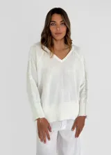 Sweater beige de tejido de punto con detalle de flecos en hombros y mangas.