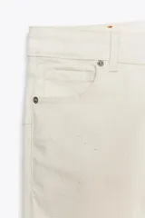 Pantalón de jean azul oscuro, de tiro bajo, corte slim fit y bootcut. Con cinco bolsillos y cierre frontal con cremallera y botón.