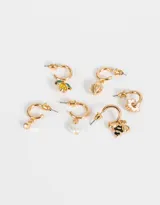 Set de tres pares de aros argolla dorados con distintos dijes colgantes: cristal amarillo, flor esmaltada blanca, perla con forma de corazón, abeja esmaltada, limón con cristales y frutilla.