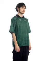 Remera deportiva verde con cuello polo negro con detalles de líneas blancas, mangas cortas con ribete negro y estampado con el logo de la marca en el pecho.