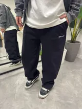 Pantalón de jogging negro oversize de algodón con cortes y logo bordado en blanco.
