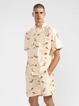 Camisa manga corta con cuello camisero, de corte recto y estampado de sirenas en tonos naranja y amarillo.