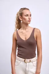 Pantalón de denim color crudo, corte ancho y tiro alto, con grandes calados florales bordados en contraste a lo largo de ambas piernas.