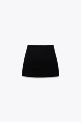 Minifalda negra de punto liso, de tiro alto y cintura elástica.