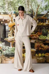 Blusa color ladrillo con rayas verticales finas, cuello polo, mangas largas y cierre parcial con botones.