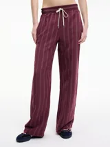Pantalón relaxed fit color borgoña con rayas verticales blancas, pretina elástica con lazo ajustable y bolsillos laterales.