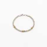 Pulsera de eslabón entrelazado en plata con detalles en oro.