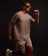 Remera deportiva marrón de corte clásico, confeccionada en tejido tech fleece con tecnología dry, cuello redondo y mangas cortas.