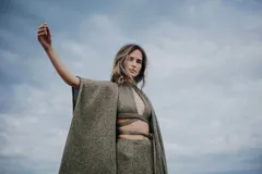 Ruana abierta color beige con brillos dorados.