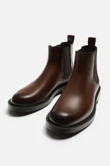 Bota Chelsea marrón de cuero, con elásticos laterales y tirador trasero. Suela negra con ligero tacón.