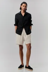 Short color crema en tejido liviano de algodón y viscosa. Modelo con cierre decorativo, elástico revestido con cordón para ajustar en la cintura, bolsillos al bies y bolsillo insertado atrás. Corte relajado para una silueta casual.