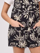 Mono corto de algodón estampado en blanco y negro, con tirantes finos y bolsillos laterales.